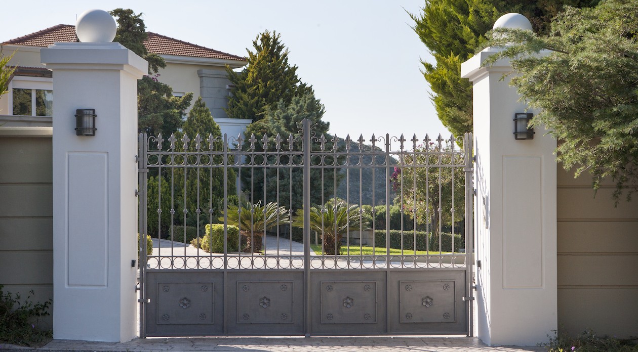 Decorated iron gates secure the villa property for sale in Rhodes Greece