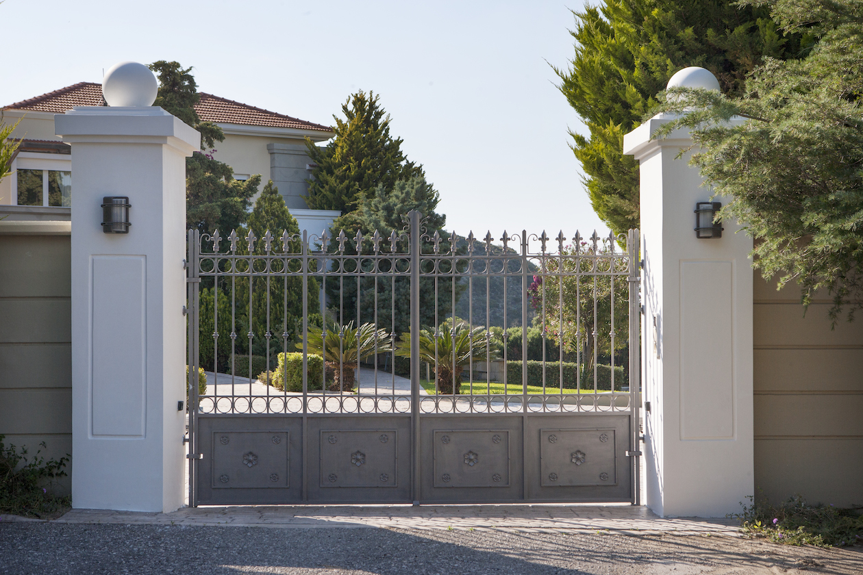 Decorated iron gates secure the villa property for sale in Rhodes Greece