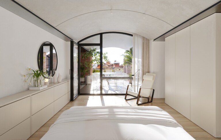 Bedroom at FIX Residences with vaulted ceiling and glazed doors opening onto a private terrace