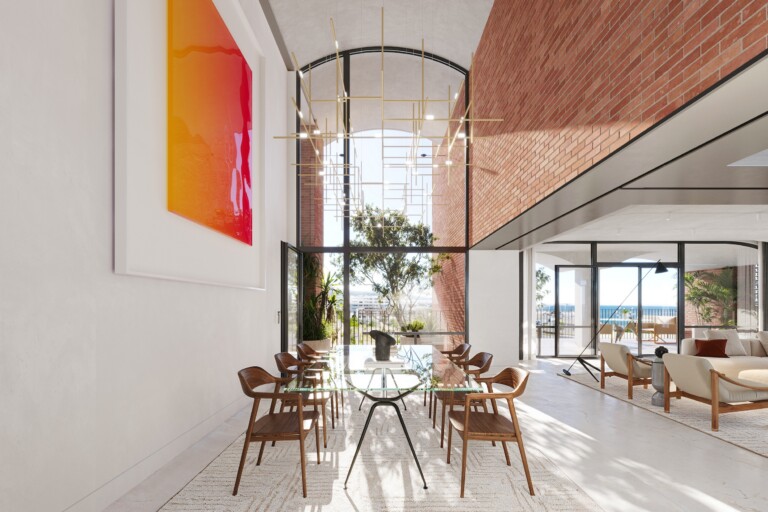 Double-height dining space of the FIX Residences penthouse with exposed brick wall and arched window, Thessaloniki