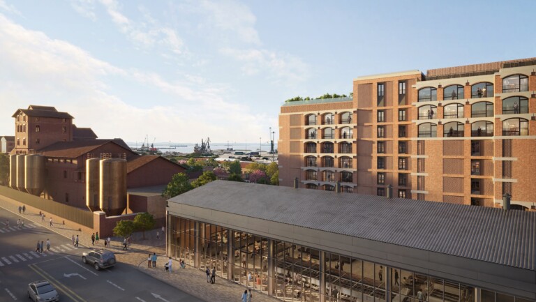FIX Residences rising behind a restored glass-roofed heritage hall of the FIX brewery, with the port of Thessaloniki beyond